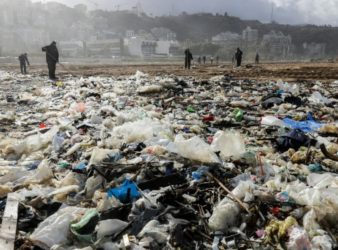 Workers clean the Zouk Mosbeh beach in 2018. (AFP | Joseph Eid)