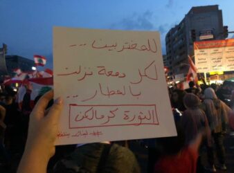 A sign that reads "To the expats, to every tear that was shed in the airports, the revolution is for you."