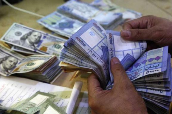 Hands of a man counting a stack of 50,000 Lebanese liras in an exchange shop in Beirut