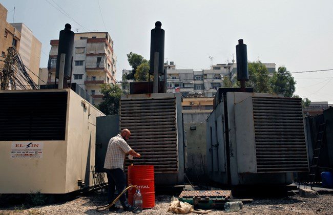 A man stands in front of two private generators in Lebanon.