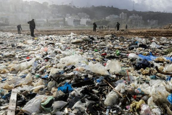 Workers clean the Zouk Mosbeh beach in 2018. (AFP | Joseph Eid)