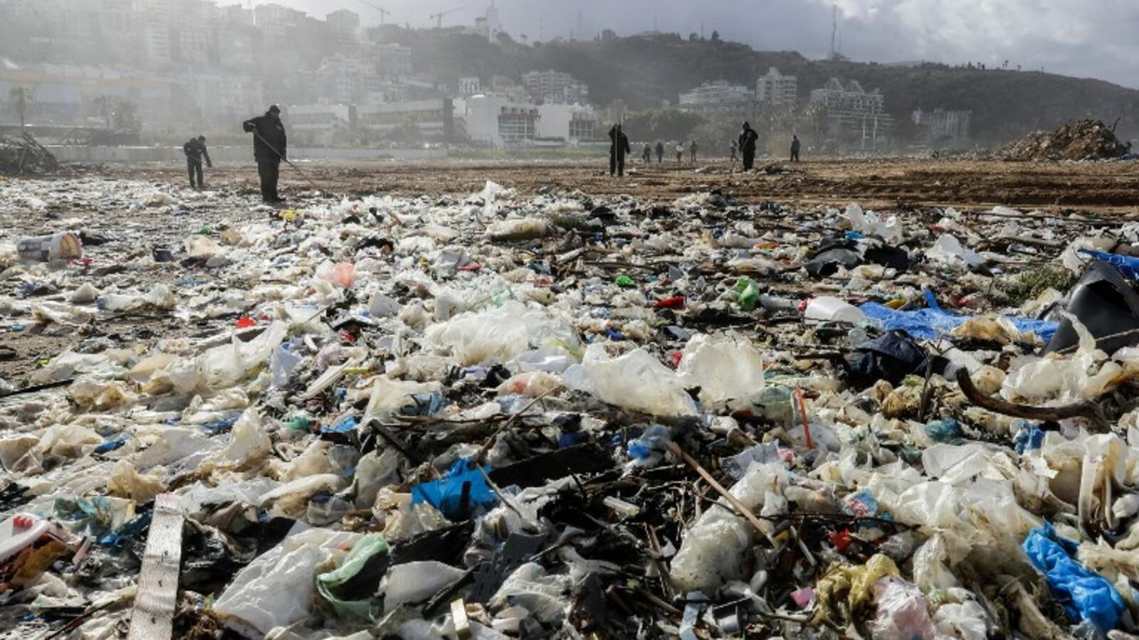 Workers clean the Zouk Mosbeh beach in 2018. (AFP | Joseph Eid)