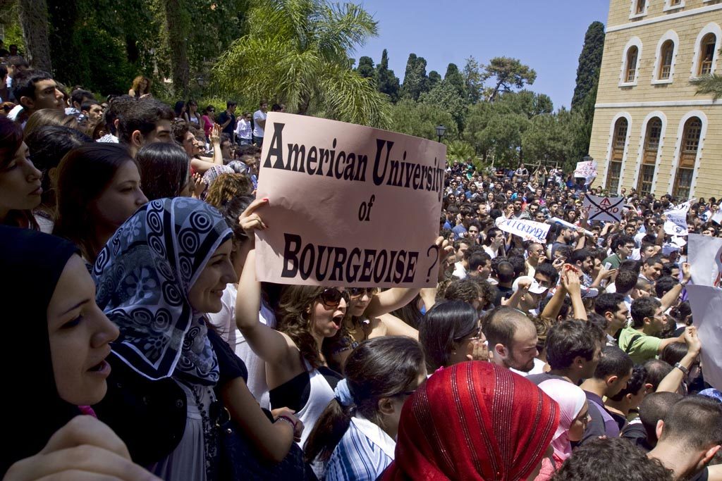 Protester carrying an "American University of Bourgeoisie?" sign from 2010 at the American University of Beirut. (Farfahinne.blogspot.com)