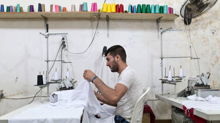 لاجئ سوري في لبنان يتعلم كيف يصمم الملابس. (لجنة الإنقاذ الدولية | جاكوب راسل)