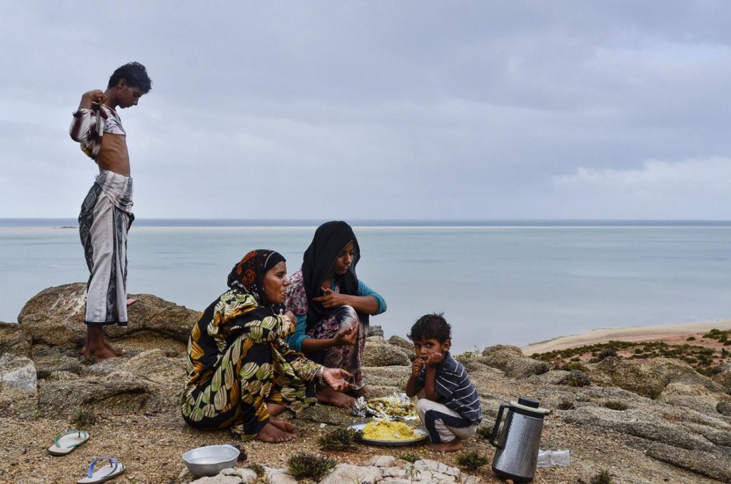 Yemen, 2014. Saadiya Eissa Soliman Abdullah and her children eat after a day clearing the hillside above their home (Photo by Amira al-Sharif, another female journalist from the anthology.)