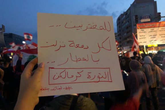 A sign that reads "To the expats, to every tear that was shed in the airports, the revolution is for you."