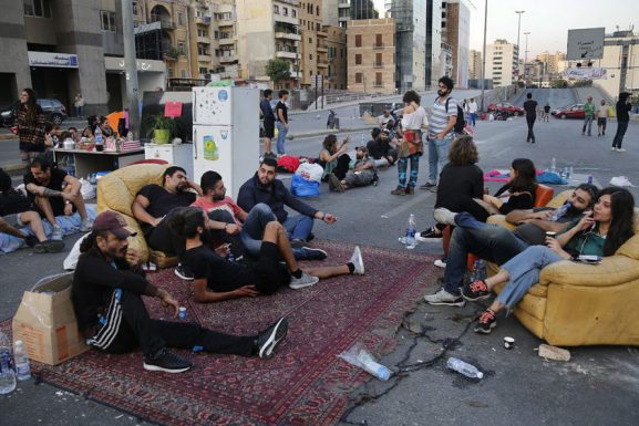 Demonstrators sit in "Beit El Cha3eb" on the Ring highway during a protest in Lebanon. (Hussein Malla/AP)