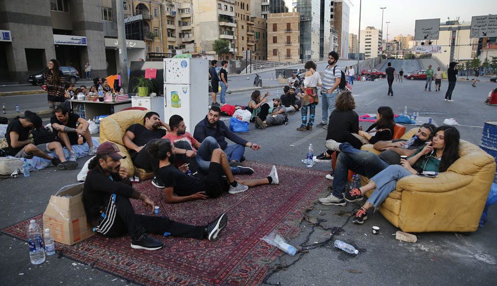 Demonstrators sit in "Beit El Cha3eb" on the Ring highway during a protest in Lebanon. (Hussein Malla/AP)