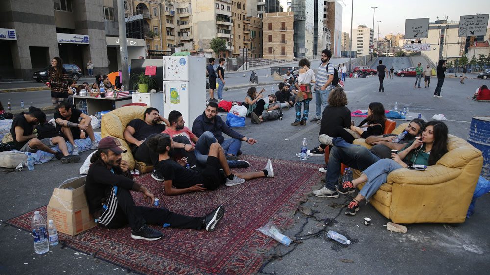 Demonstrators sit in "Beit El Cha3eb" on the Ring highway during a protest in Lebanon. (Hussein Malla/AP)