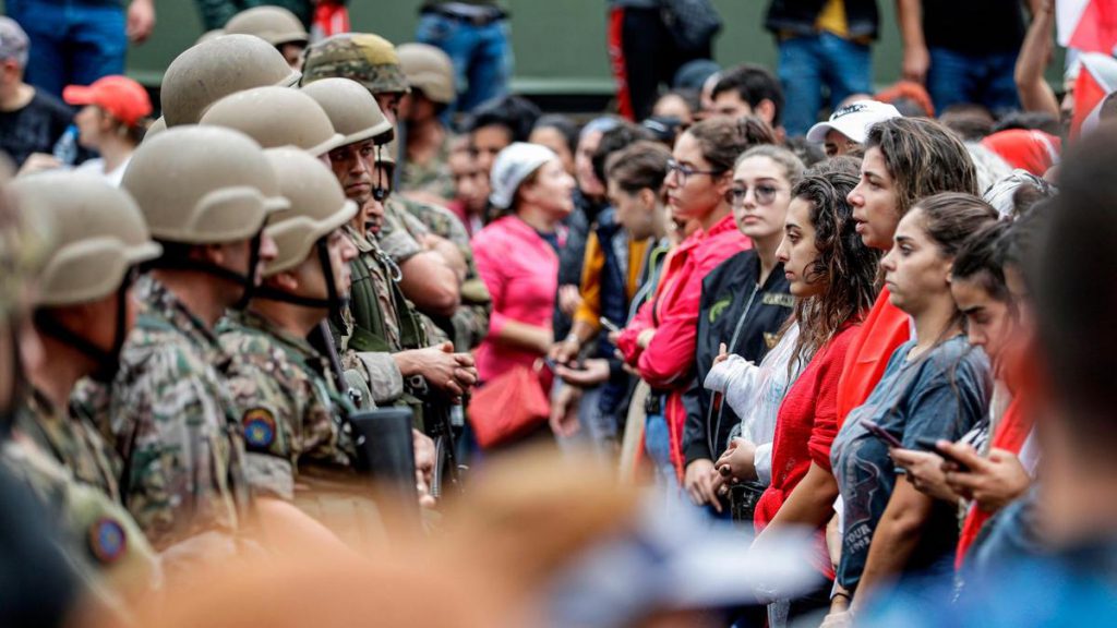 Female protesters stand in a line between Lebanese army soldiers and other protesters. (AFP / The National) - Feminist article