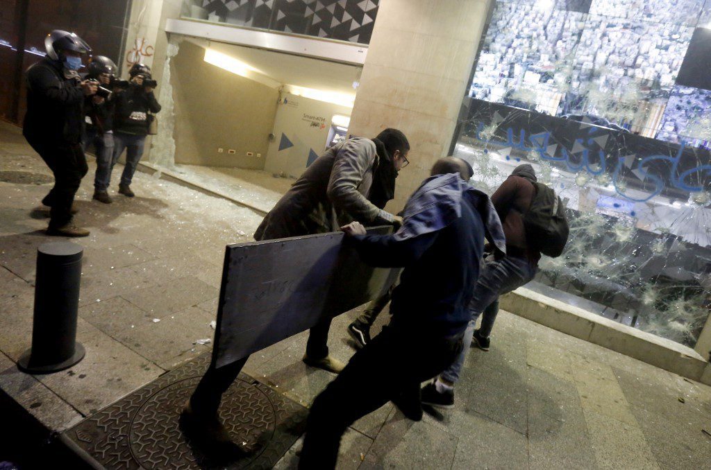 Anti-government protesters break the window of a bank in Beirut. January 2020. (Marwan Tahtah / AFP / Asia Times)