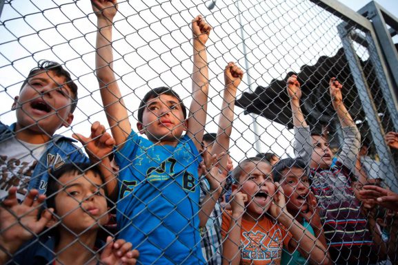 Syrian refugee children chant slogans behind a fence at a refugee camp in Turkey. (Lefteris Pitarakis / AP / The Telegraph)