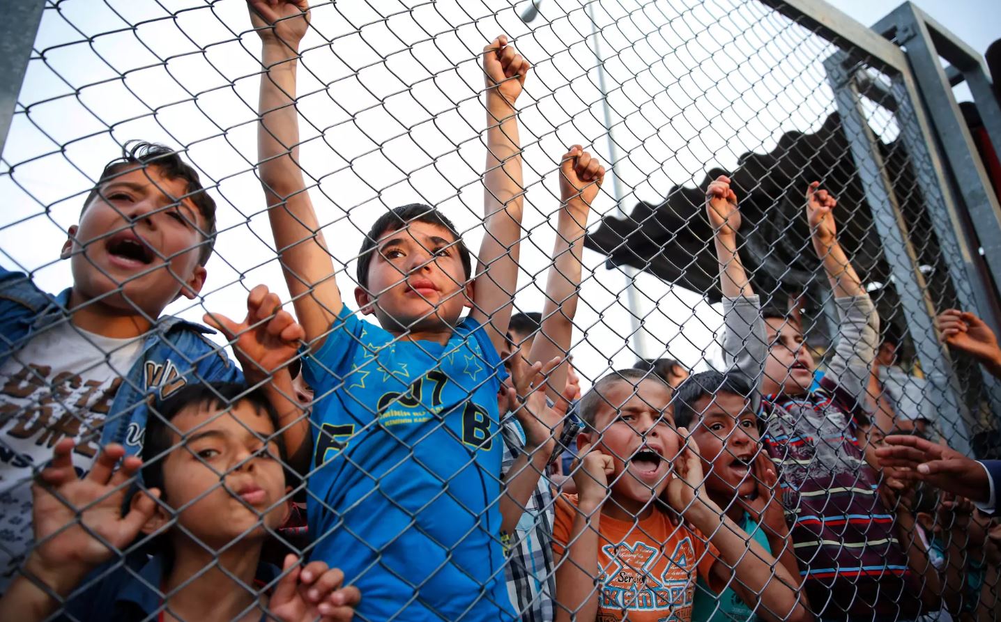 Syrian refugee children chant slogans behind a fence at a refugee camp in Turkey. (Lefteris Pitarakis / AP / The Telegraph)