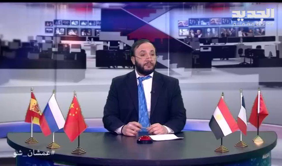 Wissam Saad sits at his desk in his persona at Al Jadeed