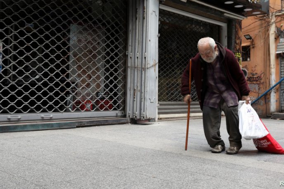 A homeless man walks past closed shops in Beirut. (PHOTO: Alhurra via REUTERS/Mohamed Azakir) | Public policy intervention article
