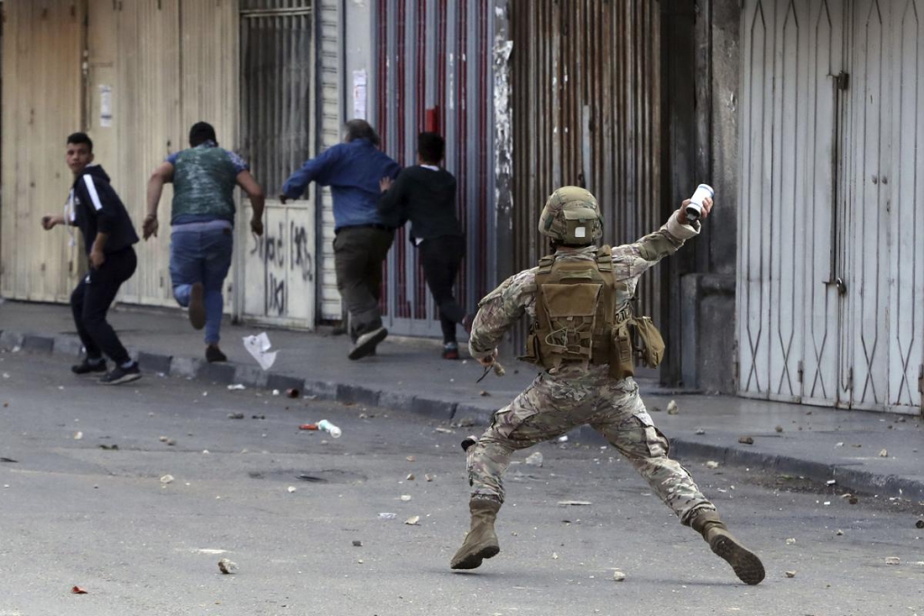 A Lebanese army soldier throws a tear gas canister towards anti-government protesters in Tripoli, Lebanon on Tuesday, April 28, 2020. (PHOTO: Bilal Hussein / AP)