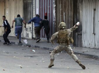 A Lebanese army soldier throws a tear gas canister towards anti-government protesters in Tripoli, Lebanon on Tuesday, April 28, 2020. (PHOTO: Bilal Hussein / AP)