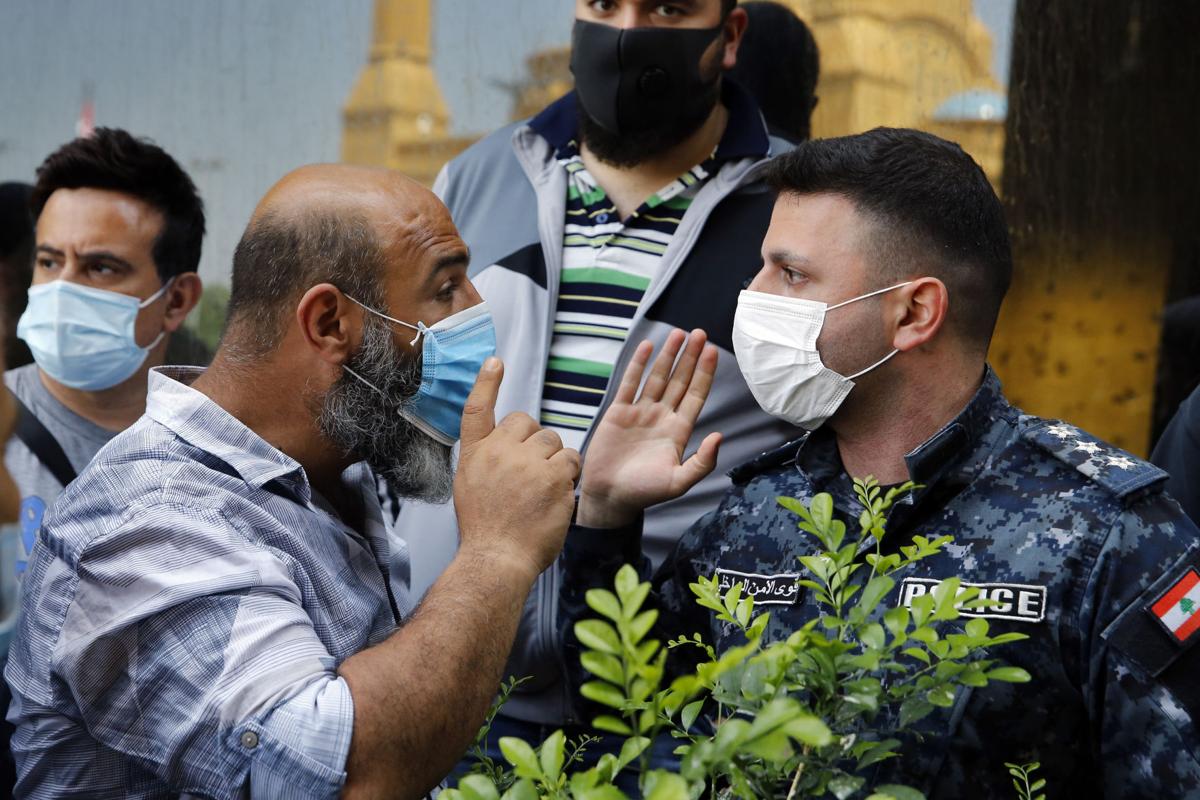 Anti-government protester yells at an Internal Security Forces police officer while demonstrating against Lebanon's worsening economic crisis in the middle of the COVID-19 pandemic. (Photo: Bilal Hussein / AP)