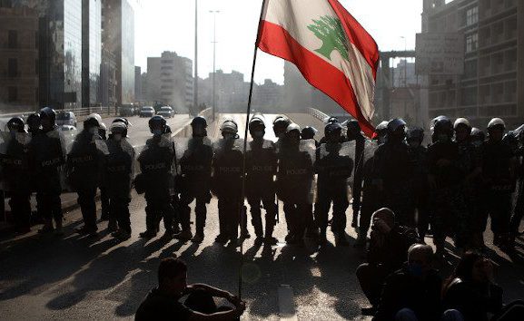 Protesters face riot police in Beirut on April 28, 2020. (PHOTO: Patrick Baz / AFP via Getty Images)
