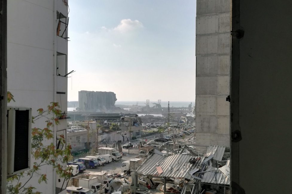Reconstruction article: The Beirut port as seen through the shattered window of a nearby home after the explosion that decimated the Lebanese capital (Photo: Michael Abounabhan)