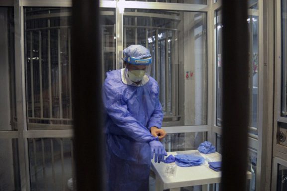 Photo: Medical staff dressed in medical gown and protective gear in a Lebanese prison. Article: WHO calls for inmate vaccination as COVID spreads in Lebanese prisons
