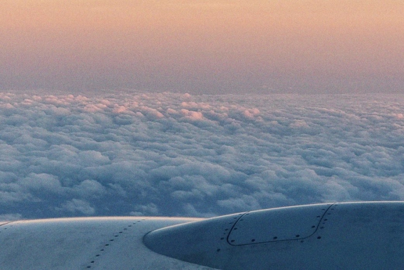 Photographer from window of a plane showing wing of plane and background full of clouds. For article: “I could not see a future”: Lebanon losing youth in new wave of emigration