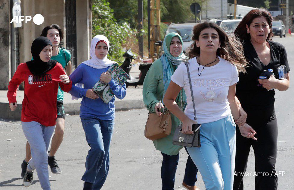 Young and visibly distressed women flee the violence in Tayouneh. Photo: Anwar Amro / AFP