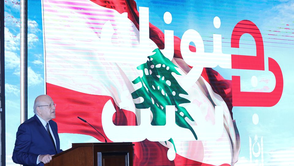 Lebanon's Prime Minister stands near "We love you in your madness" slogan on November 4, 2021. (Photo: Dalati & Nohra)